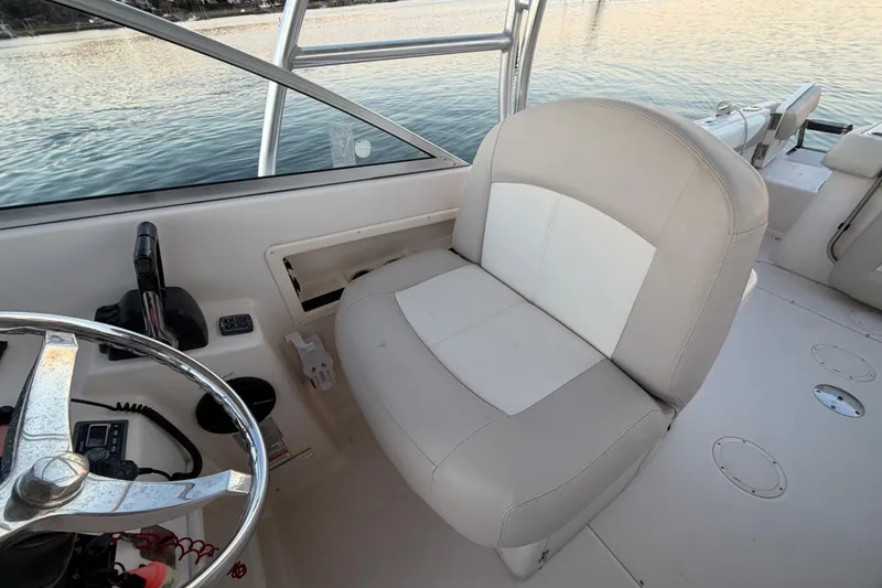 Slide: The Image of Captain's seat on 2012 Grady-White Freedom 275 boat, with steering wheel and controls. - 39