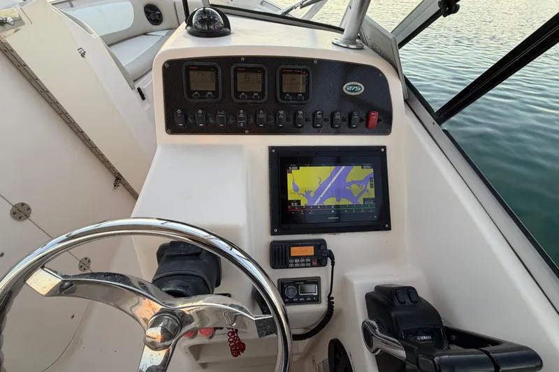 Slide: The Image of Grady-White Freedom 275 boat dashboard with navigation controls, steering wheel, and display screen, 2012 model. - 41