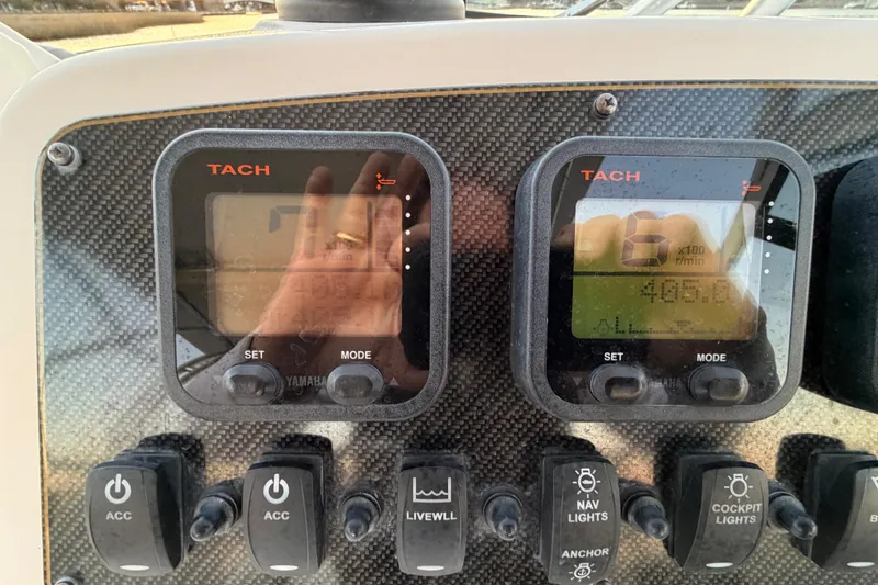 Slide: The Image of Dashboard of a 2012 Grady-White Freedom 275 boat with tachometer and switches. - 43