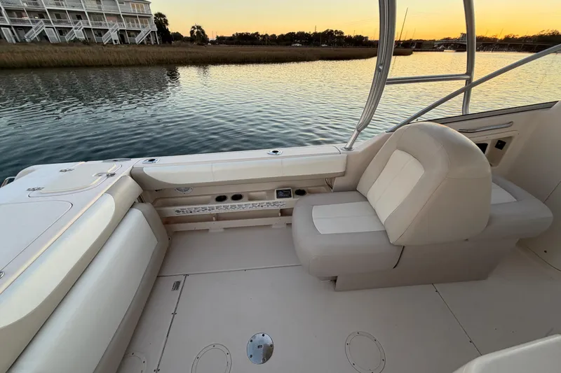 Slide: The Image of 2012 Grady-White Freedom 275 boat interior with seating, overlooking serene water at sunset. - 51
