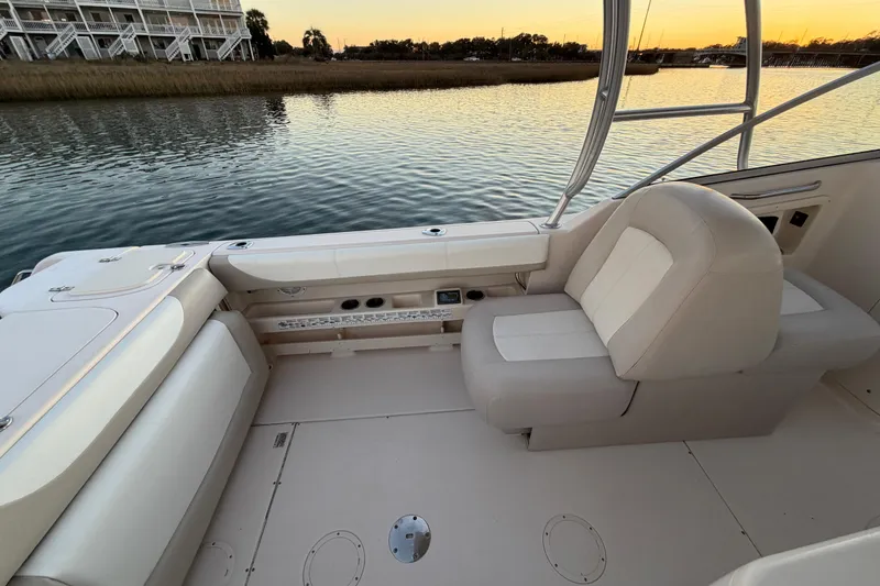 Slide: The Image of 2012 Grady-White Freedom 275 boat interior with seating, overlooking calm water at sunset. - 52