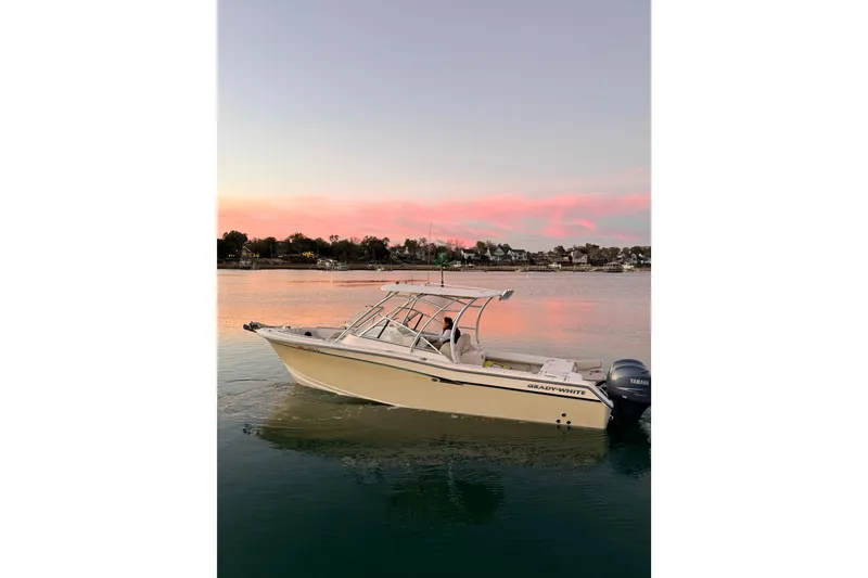 Slide: The Image of 2012 Grady-White Freedom 275 boat on calm water at sunset. - 7