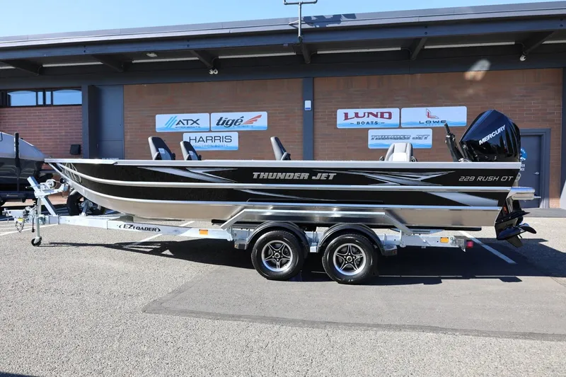 Slide: The Image of 2026 Thunder Jet 229 Rush OT boat on trailer, displayed outdoors. - 19