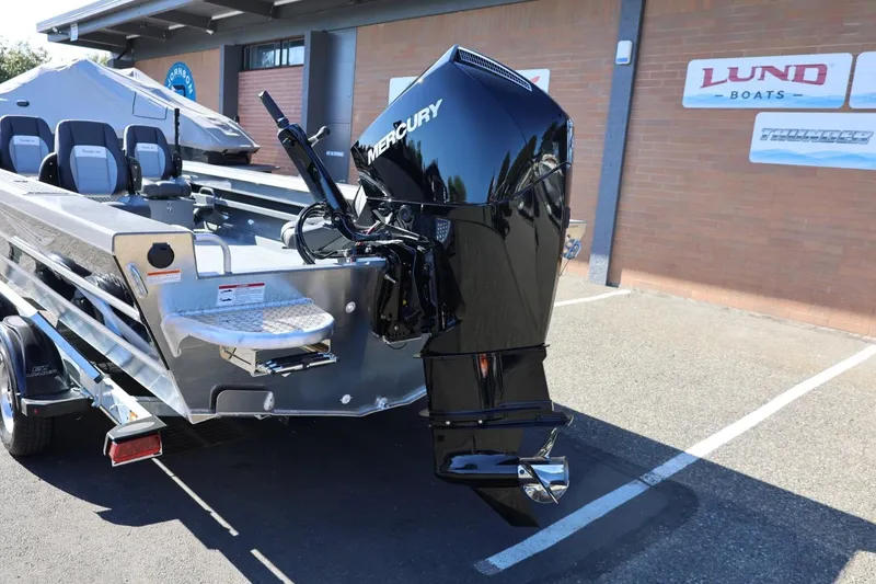 Slide: The Image of 2026 Thunder Jet 229 Rush OT boat with Mercury outboard motor, parked outside dealership. - 25