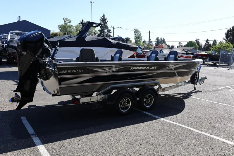 Slide: The Image of 2026 Thunder Jet 229 Rush OT boat on trailer in parking lot, side view. - 30