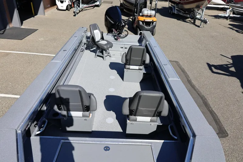 Slide: The Image of 2026 Thunder Jet 229 Rush OT boat interior with seating and motor, parked outdoors. - 39