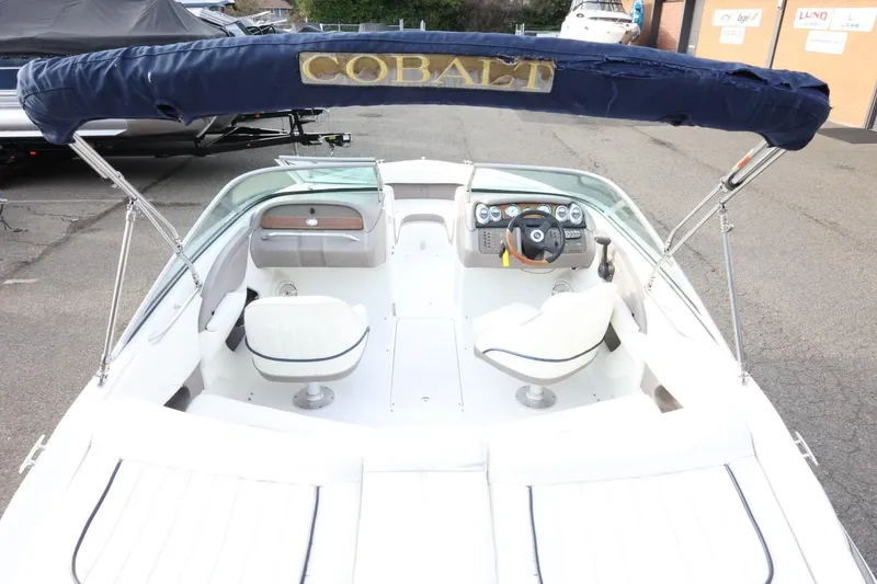 Slide: The Image of 2005 Cobalt 200 boat interior with steering wheel and seating, featuring a blue canopy. - 11