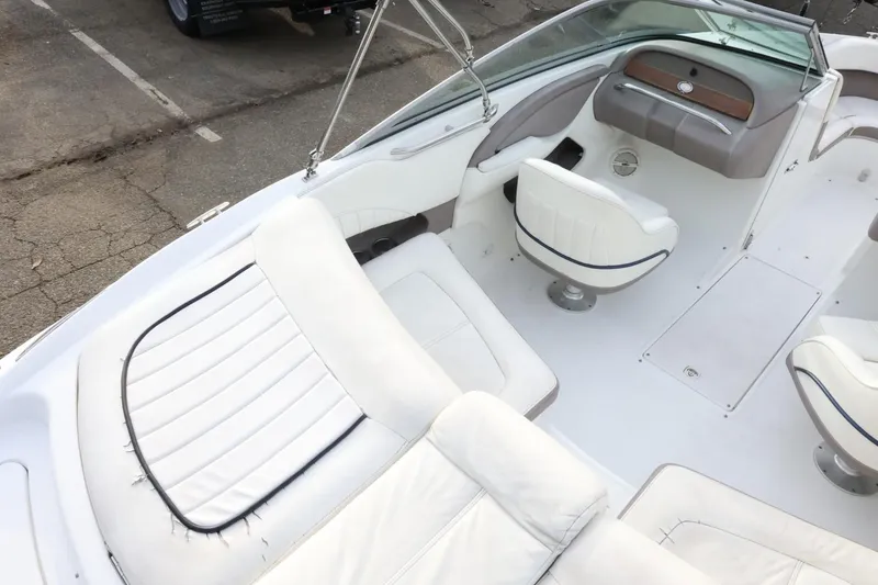 Slide: The Image of Interior of a 2005 Cobalt 200 boat with white seating and steering area. - 14