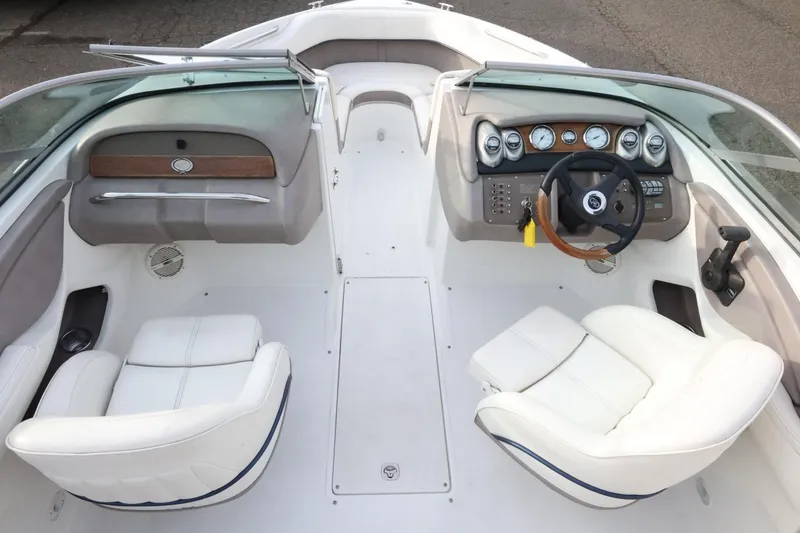 Slide: The Image of Interior of a 2005 Cobalt 200 boat with white seating and dashboard controls. - 16
