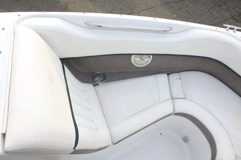 Slide: The Image of White and gray seating area of a 2005 Cobalt 200 boat, featuring a speaker and cup holder. - 18