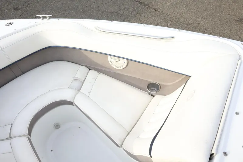 Slide: The Image of 2005 Cobalt 200 boat interior with white cushioned seating and cup holder. - 19