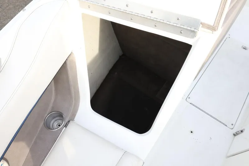 Slide: The Image of Open storage compartment on a 2005 Cobalt 200 boat with white interior. - 24