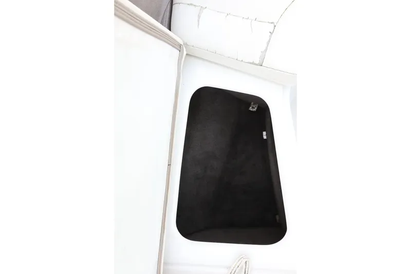 Slide: The Image of Storage compartment of a 2005 Cobalt 200 boat, featuring a black interior. - 25