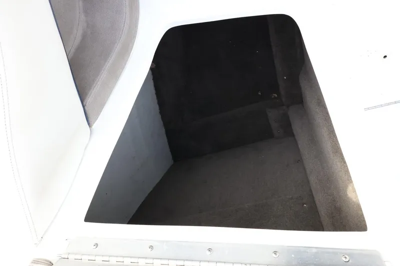 Slide: The Image of Interior storage compartment of a 2005 Cobalt 200 boat, featuring carpeted flooring. - 26