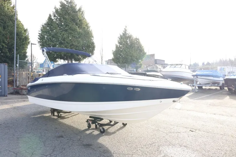 Slide: The Image of 2005 Cobalt 200 boat with blue cover in a marina parking lot. - 45