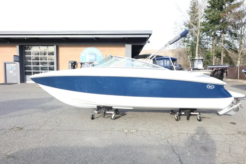 Slide: The Image of 2005 Cobalt 200 boat with blue and white exterior, parked outside a building. - 6