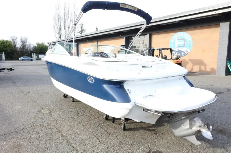 Slide: The Image of 2005 Cobalt 200 boat with blue and white exterior, parked outdoors. - 7