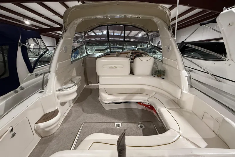 Slide: The Image of 2000 Sea Ray Sundancer 310 interior with white seating and helm in a showroom. - 11