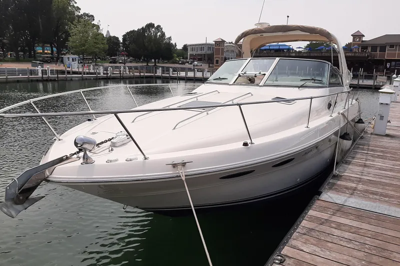 Slide: The Image of 2000 Sea Ray 310 Sundancer docked at marina, showcasing sleek design and luxury features. - 2