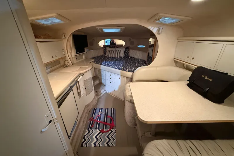 Slide: The Image of Interior of 2000 Sea Ray Sundancer 310, featuring cozy cabin with kitchenette and seating area. - 37