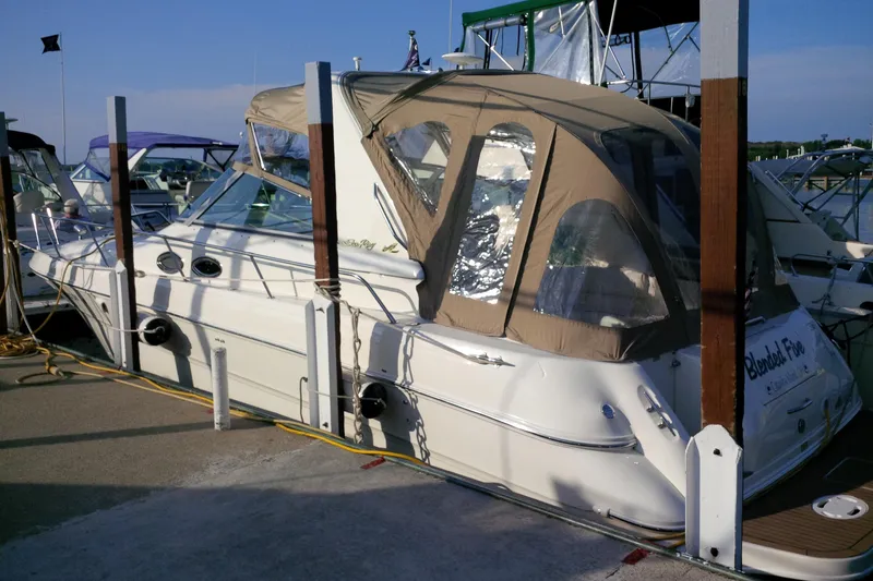 Slide: The Image of 2000 Sea Ray 310 Sundancer docked at marina with tan canopy. - 4
