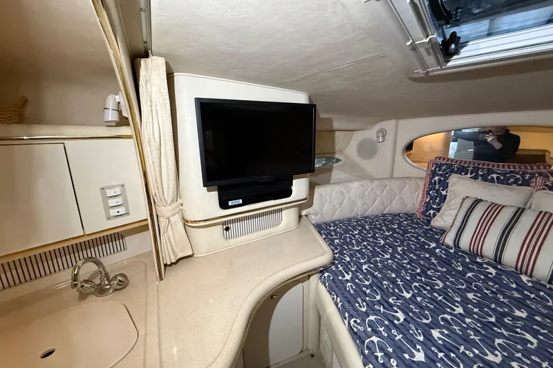 Slide: The Image of Interior of 2000 Sea Ray Sundancer 310 with cozy bed, TV, and nautical decor. - 40