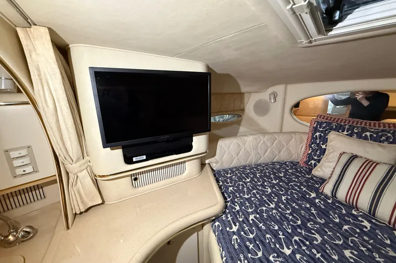 Slide: The Image of Interior of 2000 Sea Ray Sundancer 310 with TV and nautical-themed bedding. - 43