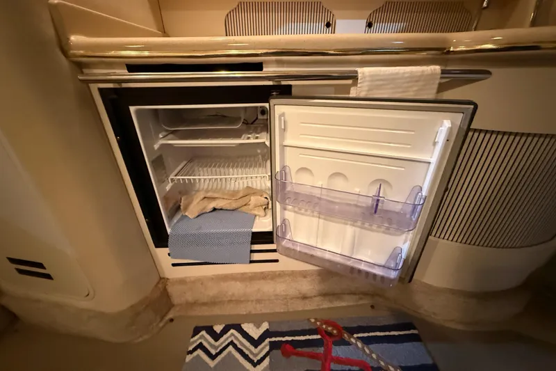 Slide: The Image of Open mini fridge inside 2000 Sea Ray Sundancer 310 boat cabin, with towels and rug nearby. - 50