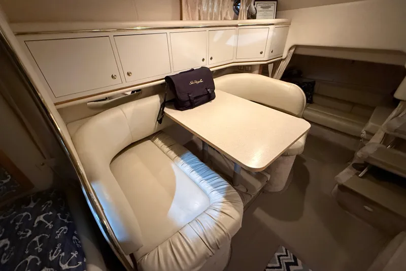 Slide: The Image of Interior of 2000 Sea Ray Sundancer 310 with cozy seating and dining table. - 51
