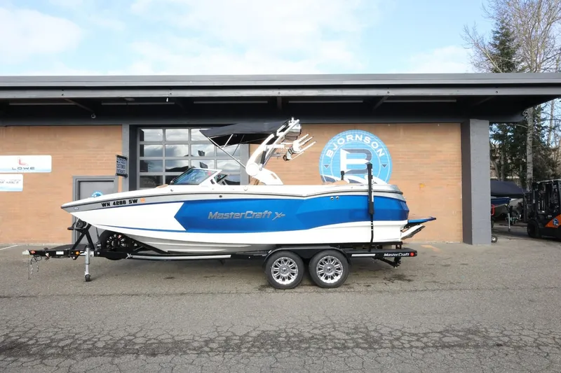 The Image of 2020 MasterCraft XStar boat on trailer, parked outside a building. - 1