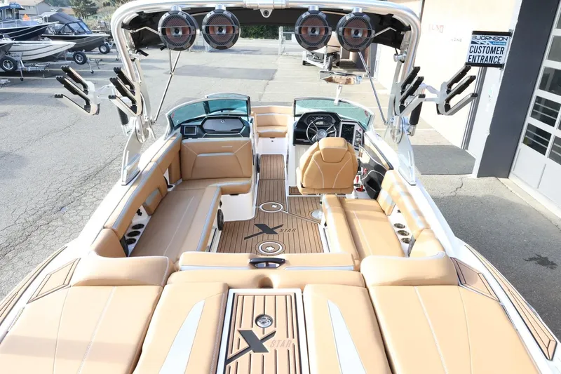 Slide: The Image of 2020 MasterCraft XStar boat interior with tan seating and advanced audio system. - 10