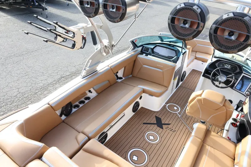 Slide: The Image of 2020 MasterCraft XStar boat interior with tan seating, advanced dashboard, and premium sound system. - 11