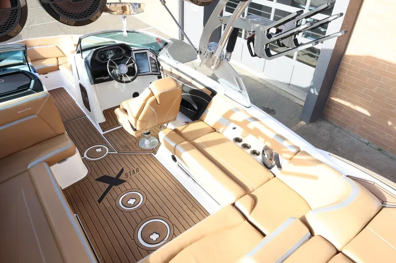 Slide: The Image of 2020 MasterCraft XStar boat interior with tan seating and modern dashboard. - 12