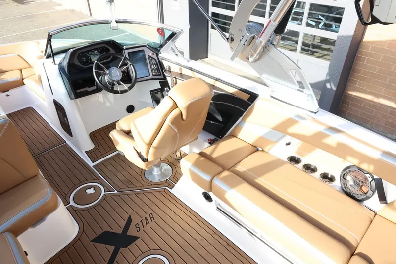 Slide: The Image of 2020 MasterCraft XStar boat interior with tan seating and modern dashboard. - 14