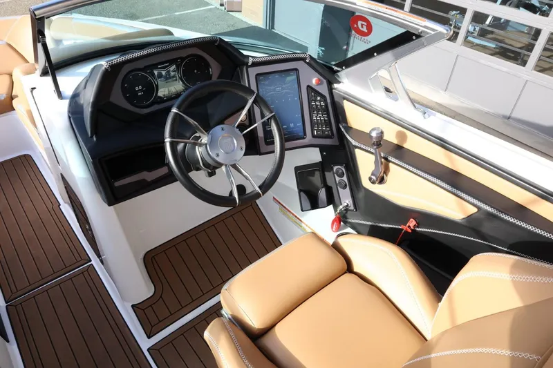 Slide: The Image of 2020 MasterCraft XStar boat interior with modern dashboard and tan seating. - 16