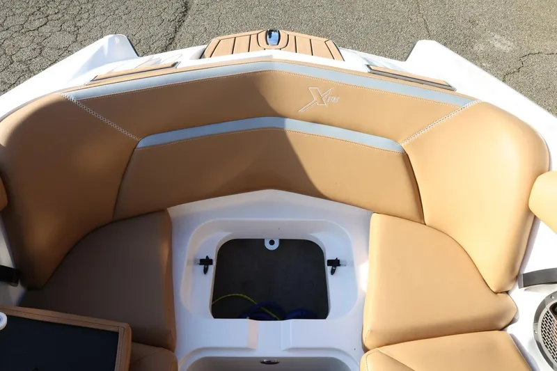 Slide: The Image of 2020 MasterCraft XStar boat interior with tan seating and storage compartment. - 22