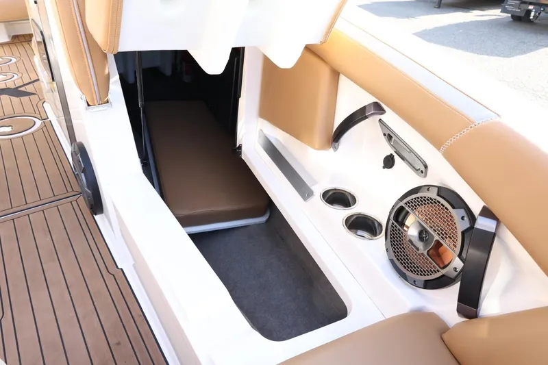 Slide: The Image of 2020 MasterCraft XStar boat interior with tan seating, speaker, and cup holders. - 23