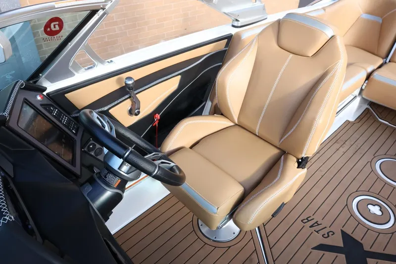 Slide: The Image of 2020 MasterCraft XStar boat interior with tan leather seats and modern dashboard. - 30
