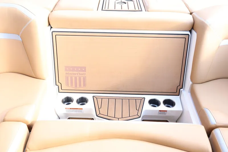 Slide: The Image of 2020 MasterCraft XStar boat interior with tan seating and cup holders. - 48