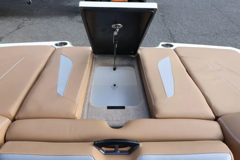 Slide: The Image of 2020 MasterCraft XStar boat with open storage compartment and tan upholstery. - 53