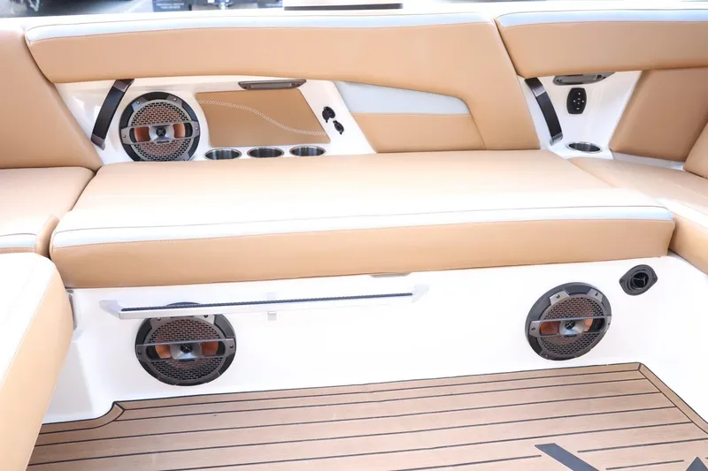 Slide: The Image of 2020 MasterCraft XStar interior with tan seating, speakers, and cup holders. - 57