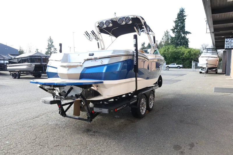 Slide: The Image of 2020 MasterCraft XStar boat on trailer, parked outdoors near dealership. - 6