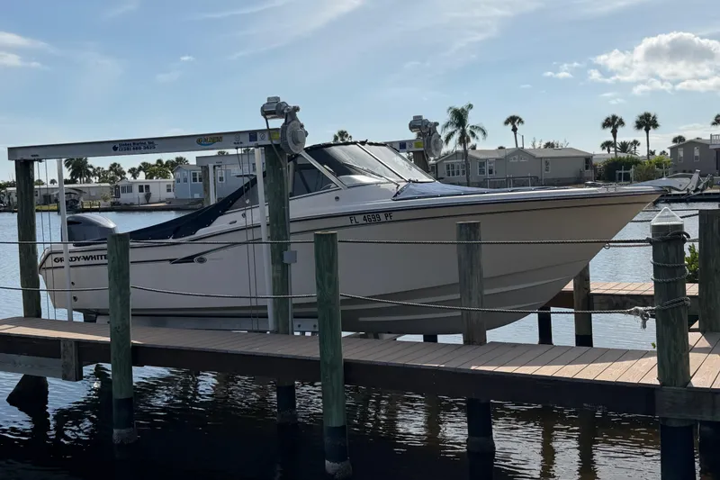 Slide: The Image of 2011 Grady-White Freedom 255 boat docked on a lift by the water. - 15