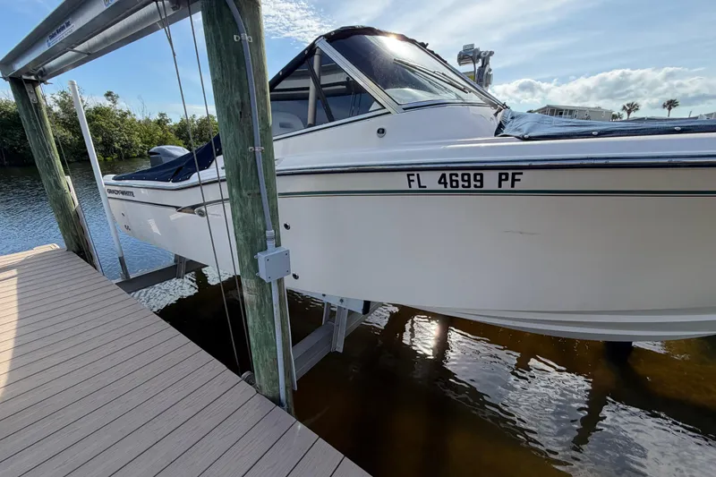 Slide: The Image of 2011 Grady-White Freedom 255 boat docked on a lift, sunny day reflection. - 20