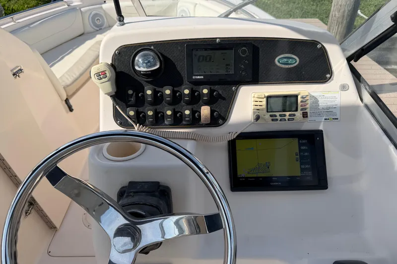 Slide: The Image of Control panel of a 2011 Grady-White Freedom 255 boat with steering wheel and navigation equipment. - 3