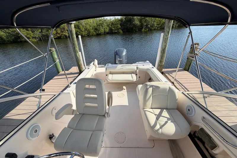 Slide: The Image of 2011 Grady-White Freedom 255 boat interior at dock, featuring comfortable seating and canopy. - 7