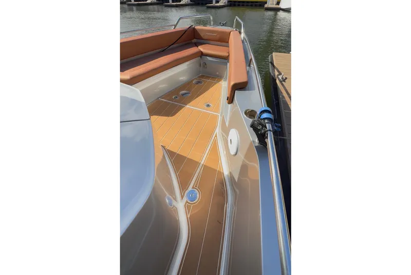 Slide: The Image of 2019 Axopar 28 Cabin boat deck with tan seating and wood finish. - 14