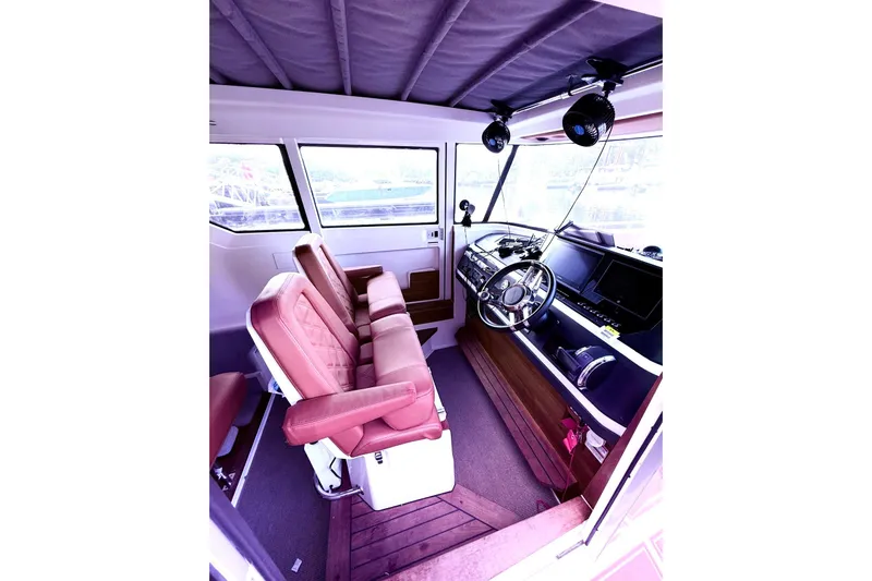 Slide: The Image of Interior of 2019 Axopar 28 Cabin boat with leather seats and modern dashboard. - 22
