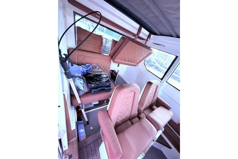 Slide: The Image of 2019 Axopar 28 Cabin interior with tan leather seats and storage items. - 23