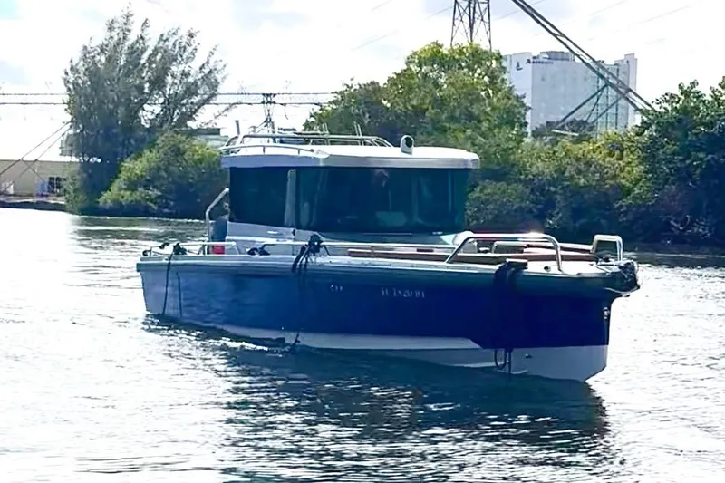 Slide: The Image of 2019 Axopar 28 Cabin boat cruising on a calm waterway. - 4